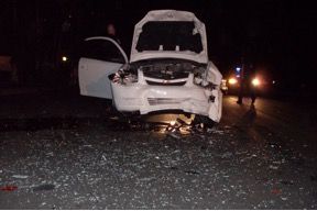 Damaged white car on the side of the road